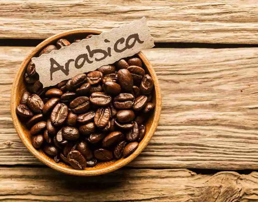 A bowl of arabica coffee beans with a label saying "arabica"