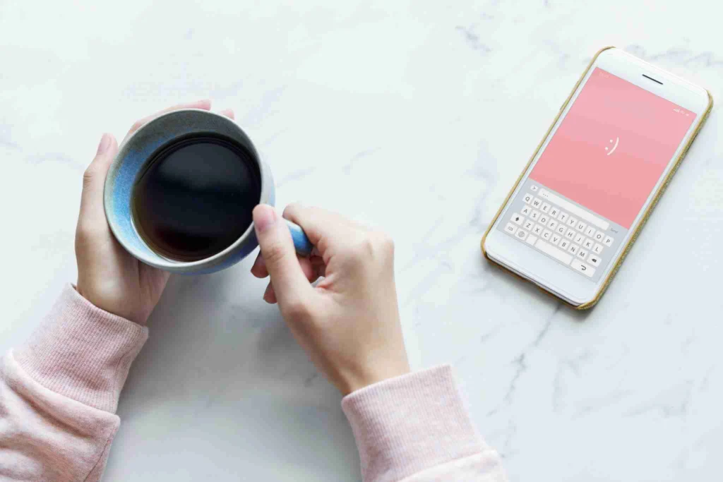 Why You Should Try Adding Salt in Coffee 7 Drinking coffee with coffee inside with your phone next to me.