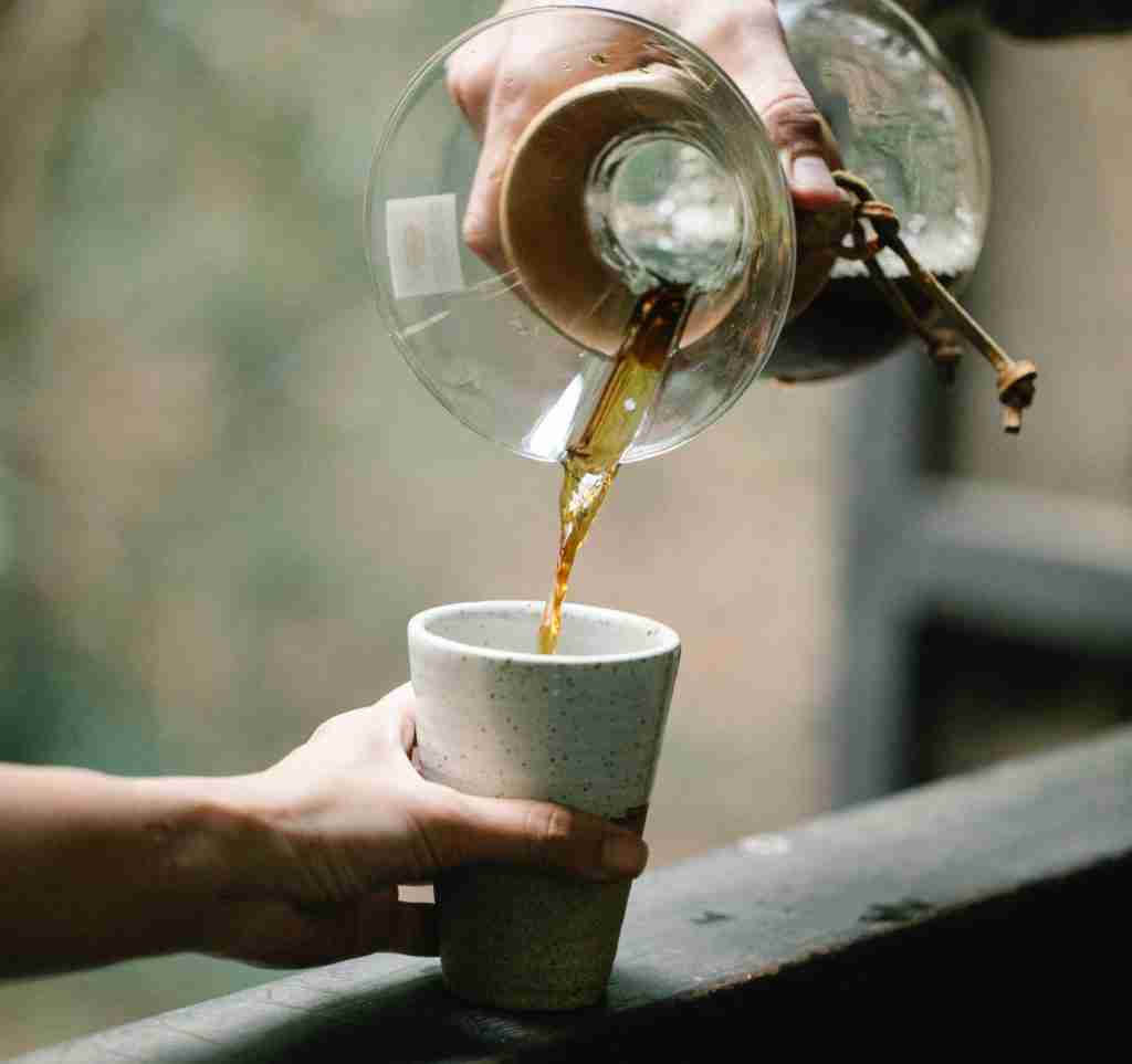 pouring coffee from chemex into ceramic cup