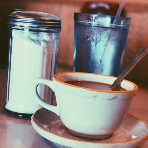 white-ceramic-mug-fill-with-coffee-beside-condiment-shaker-808504